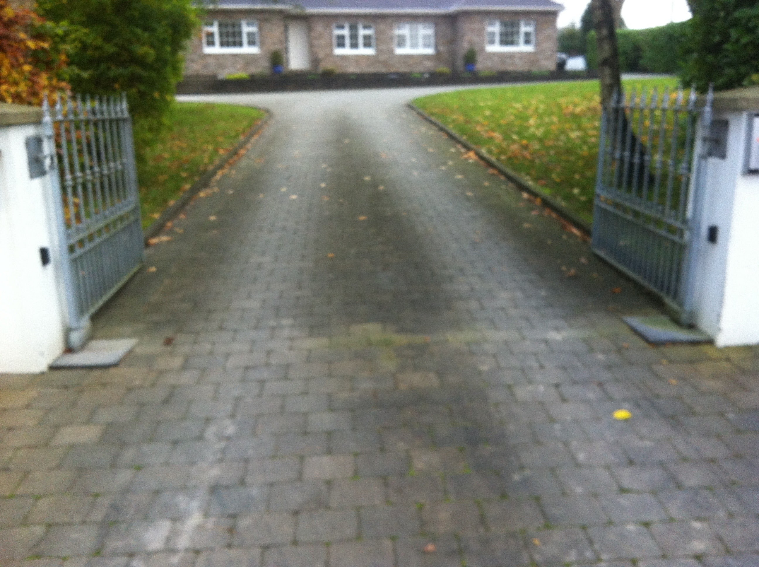Block paving driveway darkened by moss and algae, before cleaning