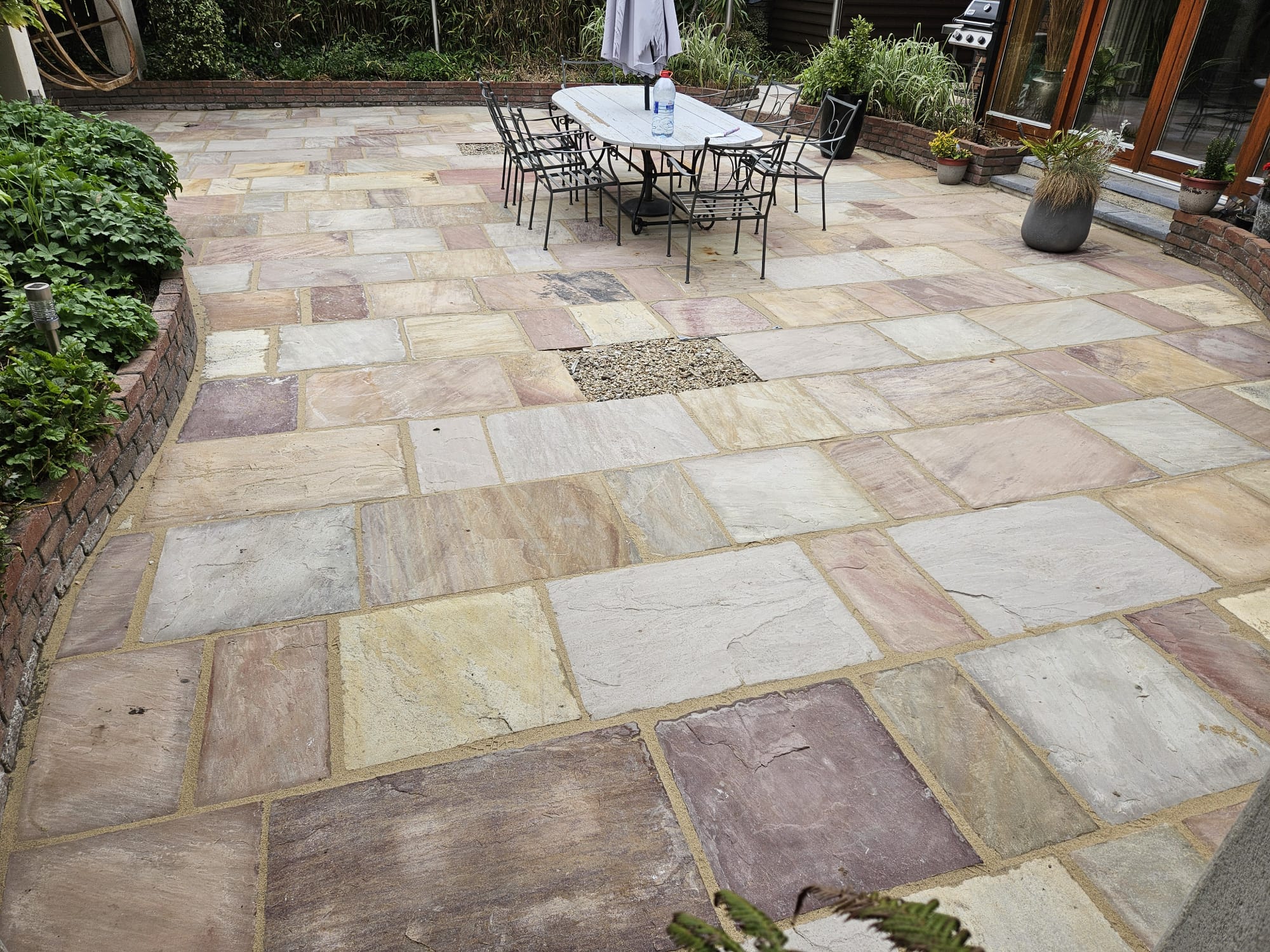 Indian sandstone patio cleaned and re-jointed, garden furniture in place