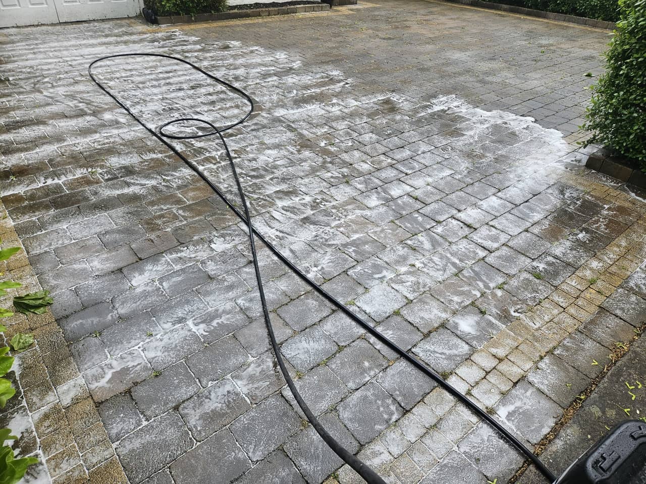 Block paving driveway mid-treatment, cleaning wash working into the surface