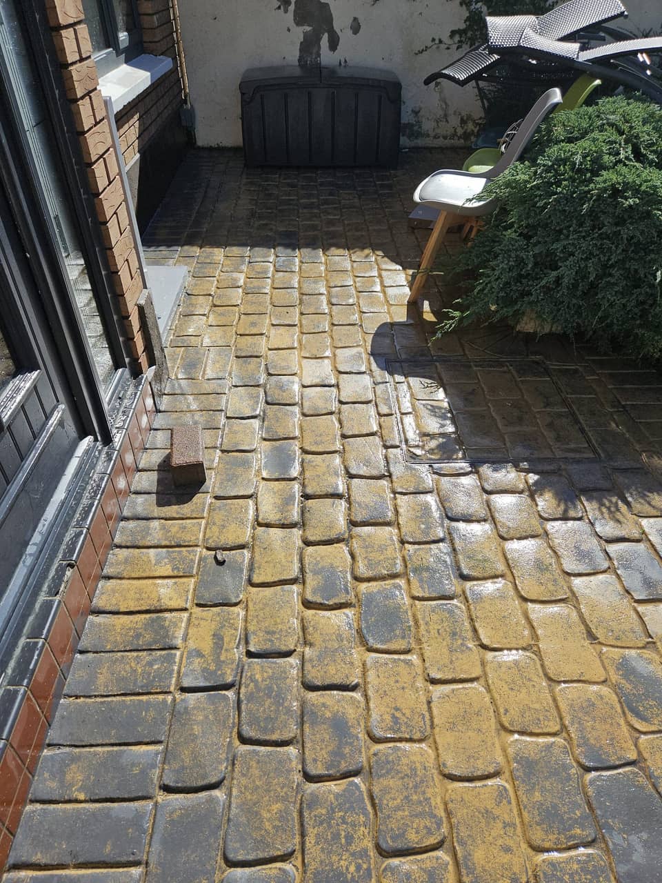 Imprinted concrete cobbles before cleaning, algae-stained